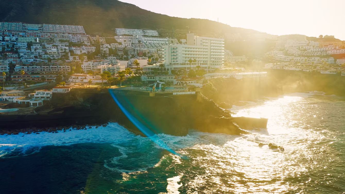 Coastal resort town in low sunset light, shot from the air