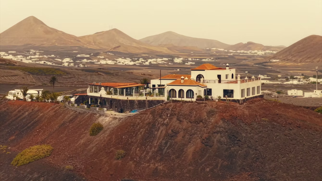 White resort buildings on red volcanic ground at sunset