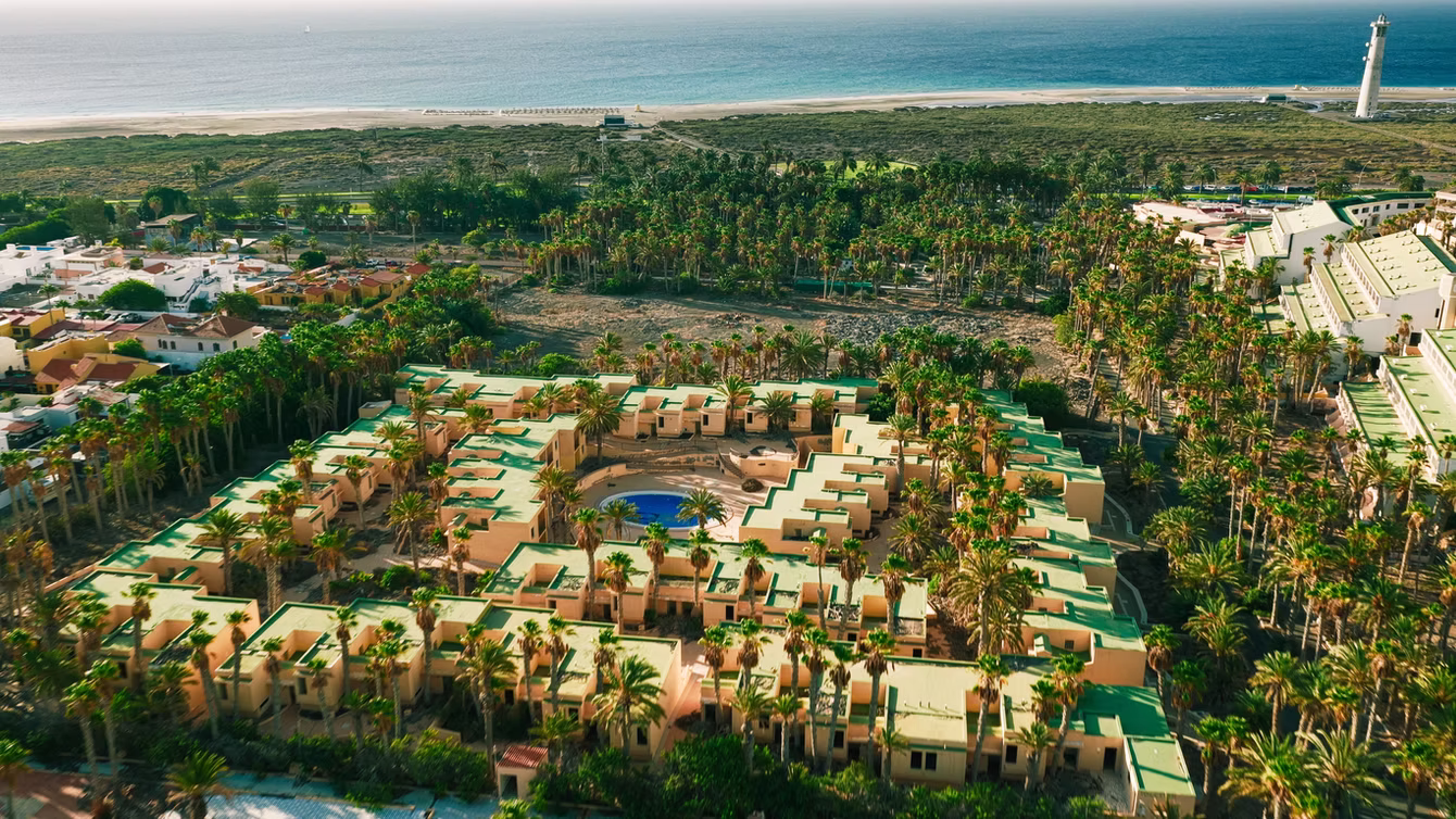 Low-rise resort spread through palm gardens, seen from the air